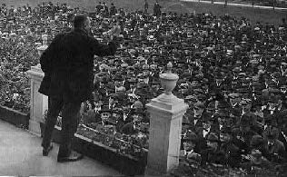 Black & white photo of a union member giving a speech to a large crowd
